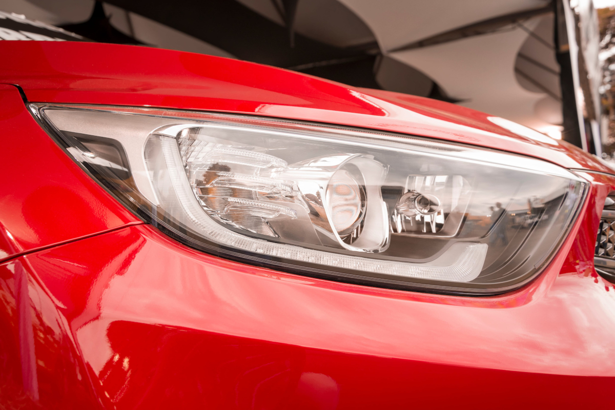 front headlight and hood of a red car