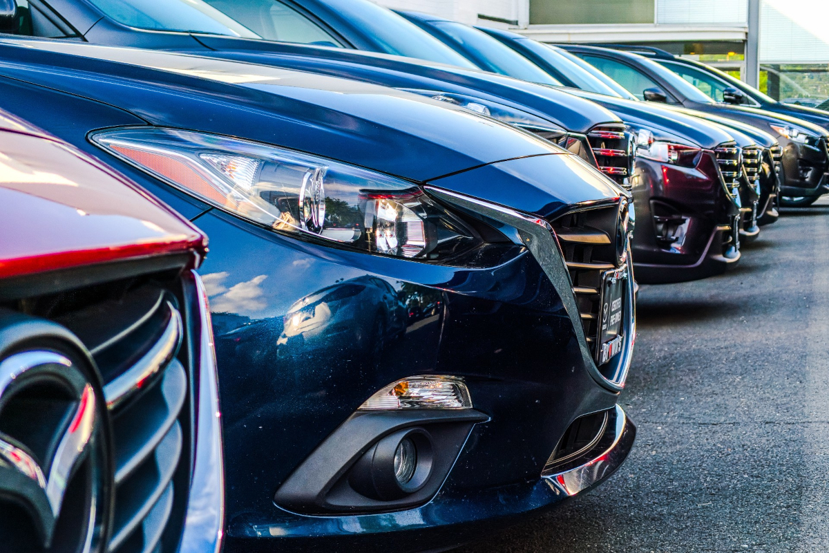 rows of cars parked in a row at a dealership lot