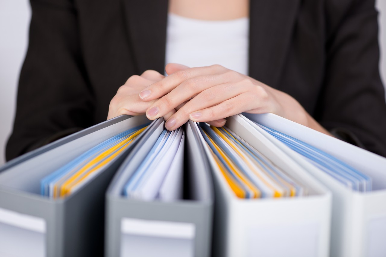 Professional in front of books full of document papers